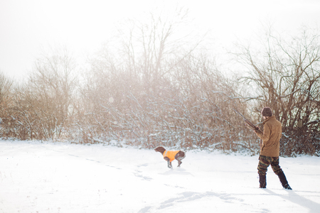man and dog running after the preyの写真素材