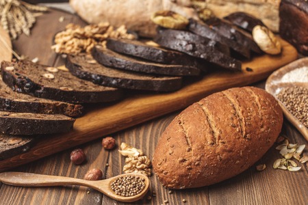 Whole grain multigrain bread, whole and sliced, contains seeds isolated on blackの写真素材