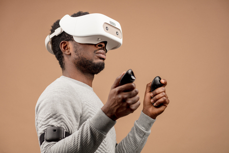 Man in VR glasses now is playing 3D game but Mankind stands on the threshold of a new era of controlling objects in virtual reality from the real world.の写真素材