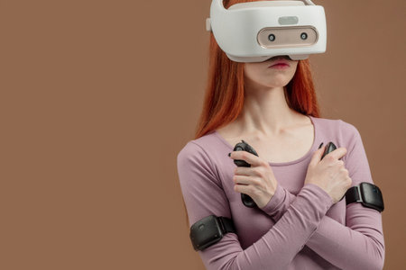 Redhead young female student putting VR goggles on head, experiencing virtual reality using 3d...