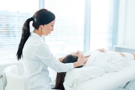 Cosmetology image of beautician doing head massage or prepare female patient to hardware cosmetology procedures. Beauty concept. Cosmetology concept. Cosmetology salon.の写真素材