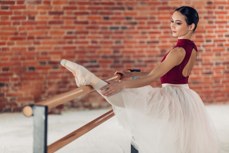 attractive gymnast warming up and stretching her legs muscles, close up photo, girl attends classic lessonの写真素材
