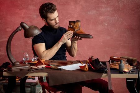 cute cobbler exploring the defect of the shoes. close up photo.の写真素材