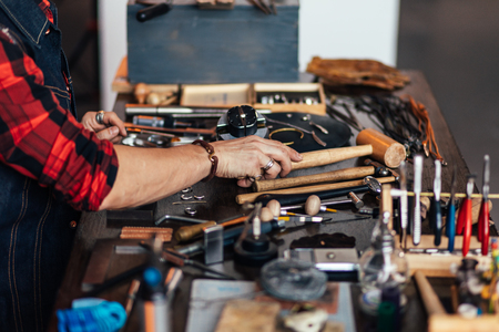 master putting tools on the table. side view cropped photo, goldsmith has finished his workの写真素材
