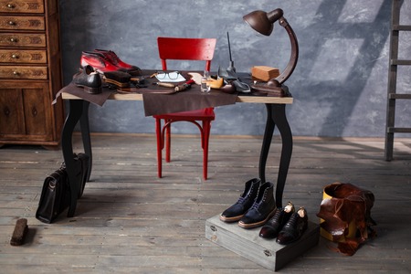 empty shoemaker's work table . messy desk with necessary tools for repair shoesの写真素材