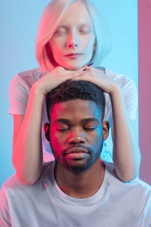 Portrait of calm beautiful mixed race couple with closed eyes . meditation, yoga, mental health, concentration on thoughts, positive thinkingの写真素材