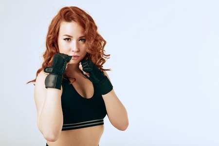 Beautiful caucasian redhead sportive fit woman exercising on white studio backgroundの写真素材