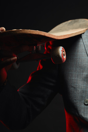 Young handsome African businessman with longboard close up, focus on hand holding longboardの写真素材