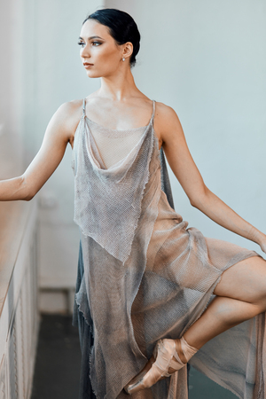 Ballerina in pointes and elegant scenic suit warms up before the performance, flexing long slender foot. Old-school ballet. Prima ballerina.の写真素材