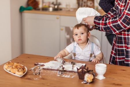 Infant cook baby with dough rolling pin, isolated on a white background.の写真素材