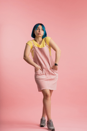 cute attractive girl looking away, having doubtful and indecisive expression, as if she doent know what to say.Wait a minute, let me think.shyness, embarrassment concepts. full length photoの写真素材