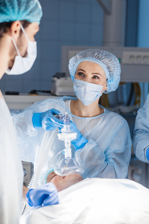Team of experienced doctor and female assistants preparing diseased man to difficult abdominal surgery, using the chance to save patient s life, and there is no greater calling in the world than thatの写真素材