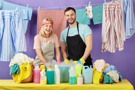 young couple advertising washing powder. close up portrait. isolated blue background. studio shot.の写真素材