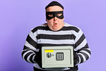 puzzled unhappy man cannot open the safe, difficulties in crime. intellectual task, sum. close up...