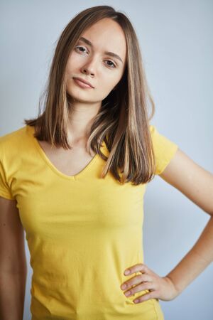 beautiful female with UV damaged on her face with hand on the hip looking at the camera , close up portrait, isolated white backgroundの写真素材