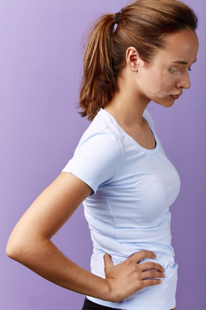 sad unhappy girl with hands on the hips looking down, close up side view photo. unusual tipe of...