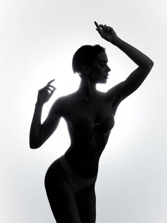 sexy young woman with healthy tanned skin enjoying dancing in the studio. girl gets plasure from music. close up photoの写真素材