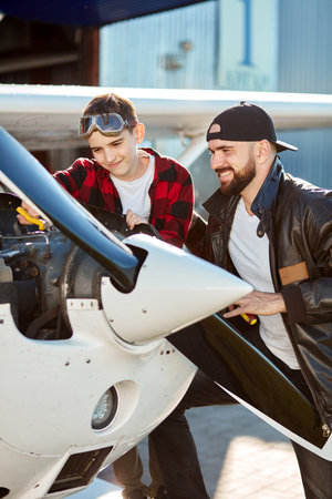 vertical shot of handsome young man with screwdriver and cute boy with pliers making together...