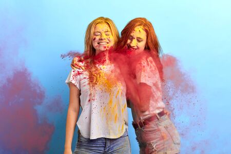 blonde and ginger girls getting pleasure from holi festival, the blossoming of love, friendship. studio shotの写真素材