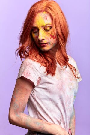 romantic beautiful girl with yellow eyelashes with bright red hair looking down. isolated blue background, studio shotの写真素材