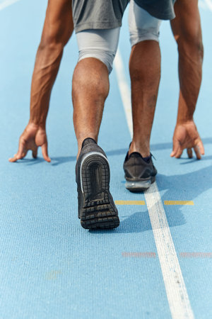 african afro sportsman standing in starting position while taking part in the competition. close up...