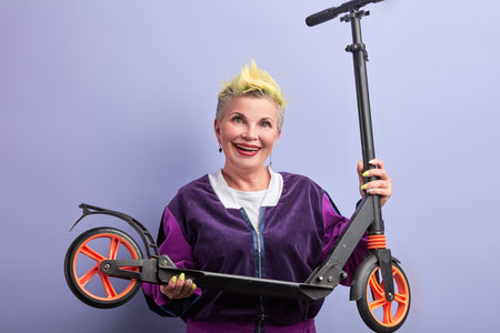 happy smiling old lady going to ride a scooter. close up portrait.entertainment. granny has received...