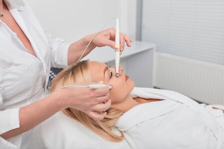 female blonde client gets rid of scara,pain and insomnia , treats cellulite, close up photo. woman lying at beauty salon and getting modern treatmentの写真素材