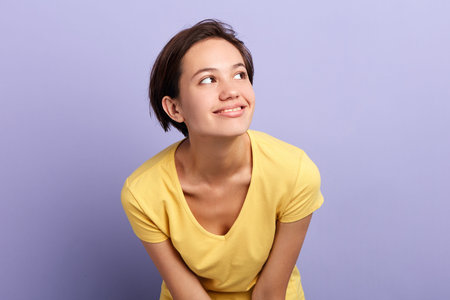Beautiful charming young woman dreaming,looking up, isolated on blue background. close up pportrait, isolated blue background, studio shot. facial expression. place for advertの写真素材