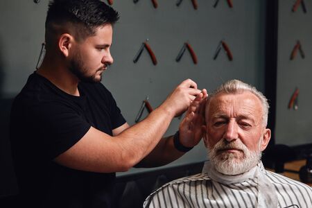 talented barber creating new style fo old client. close up photoの写真素材