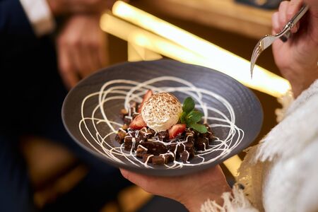 High european cuisine. People eat sweet dessert from beautiful dish and enjoyの写真素材