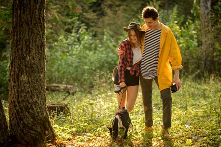 young loving couple enjoying walking with afro dog, full length photo. love, family, relationshipの写真素材
