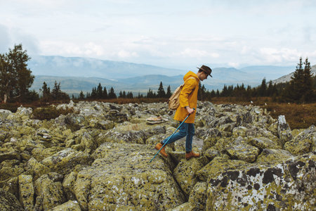 ambitious active guy with a travel backpack walking on the top mountain, extreme sport, full length...