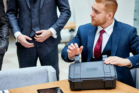 Caucasian man in tuxedo showing new modern technologies to sheikh in white suit. Business concept