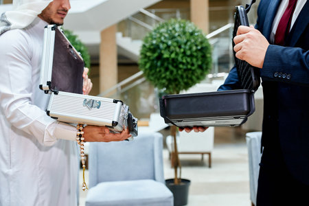 Caucasians came with case of new technology to meeting, show. Sheikhs show money in case to buy