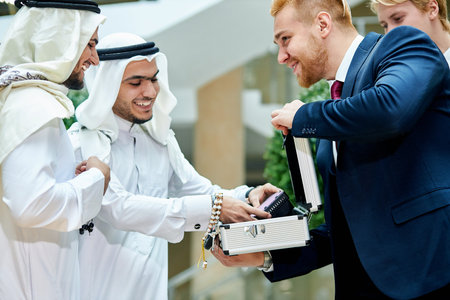 Two young businessmen from dubai listen to caucasian businessman