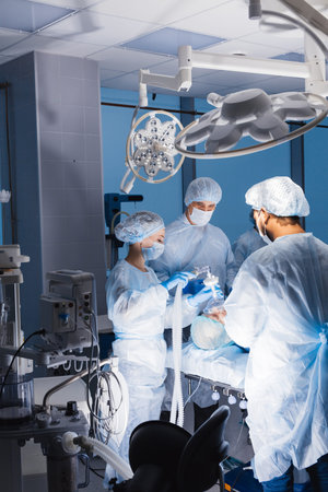 Medical team preparing equipment for surgery in operation room.