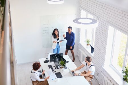 Top view on international business team laughing together in office. white interiorの写真素材