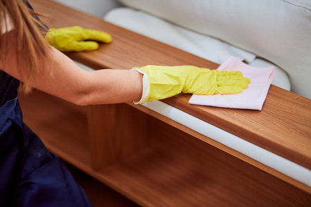 Closeup of woman hands in yellow rubber gloves for cleaning, dust off