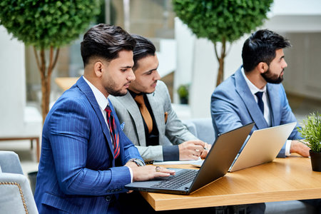 Side view on young politicians conduct negotiations about new project, new deal, using laptops,...