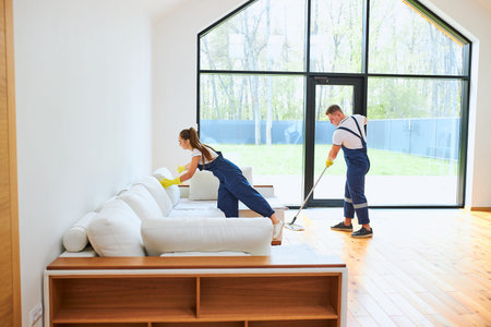 Two person in blue uniform, cleaning equipment, wearing yellow rubber gloves mop floor, preparing...