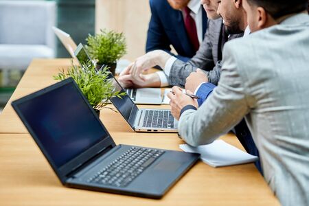Close-up of laptop, co-working, businessmen sitting on table. Men in tuxedo use modern technologies while discussing project, laptop, computerの写真素材