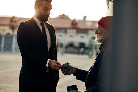 Young business man in suit help vagrant man in street, giving money donation. people relationship...