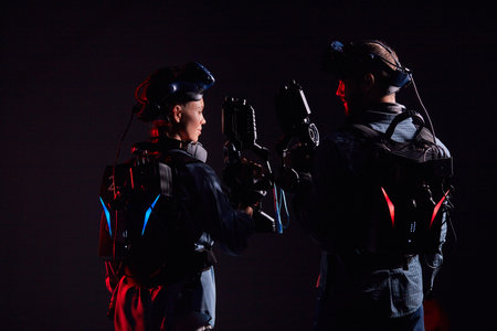 Man and woman stand opposite each other, holding vr weapons, team in virtual reality game. Isolated...