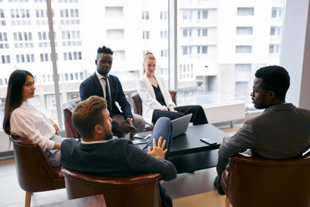 Confident business partners gathered in office to discuss interesting joined business ideas, share...