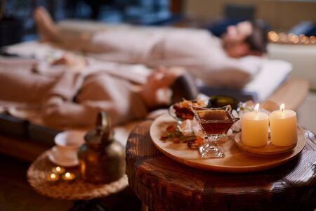 Attractive caucasian woman and man spend time in spa salon and enjoy drinking teaの写真素材