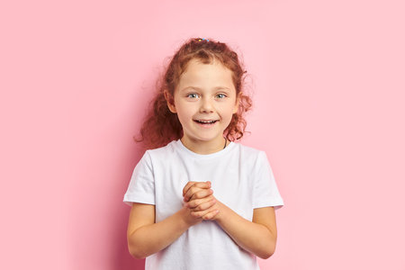 Beautiful child with red hair wearing white t-shirt show different emotions, looking at camera....