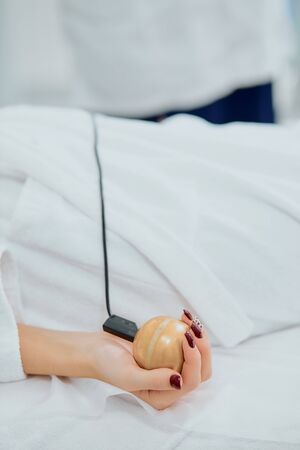 close-up of womans hand lying on bed in hospital. examining health with the use of special medical equipmentの写真素材
