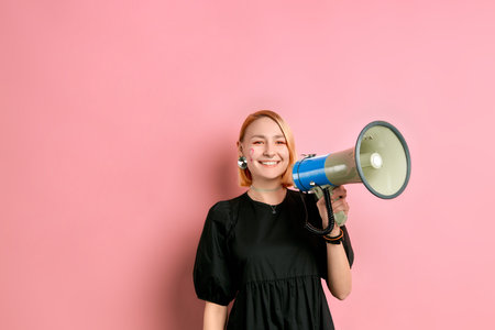 portrait of good-looking caucasian young female holding megaphone in hands, fighting for women...