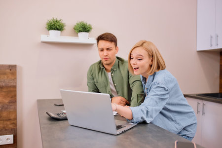 happy excited married couple use laptop and documents, discuss mortgage, analyzing together, happy...