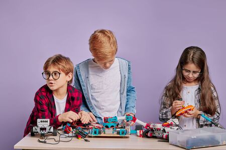 gifted smart clever children, kids interested in robotics, try to assemble and create new robot togetherの写真素材
